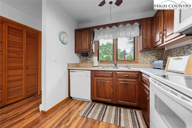 a kitchen with granite countertop a sink window and cabinets