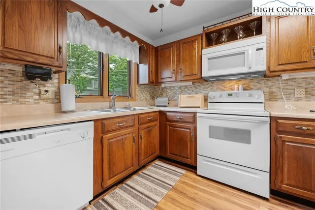 a kitchen with stainless steel appliances granite countertop a sink a stove and cabinets