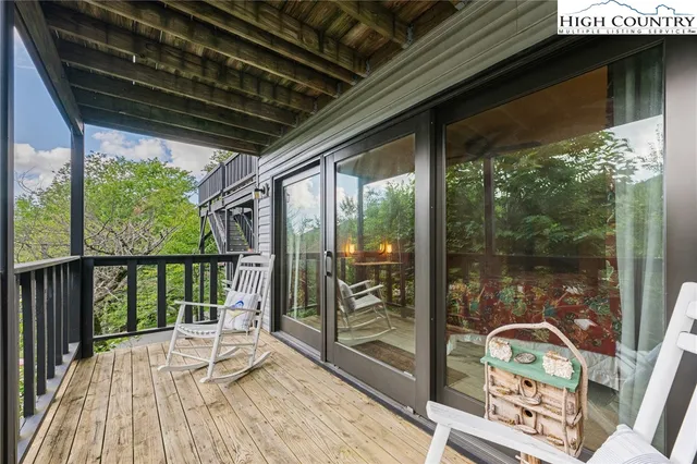 a balcony with wooden floor table and chairs