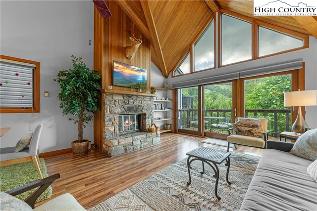 a living room with fireplace furniture and a large window