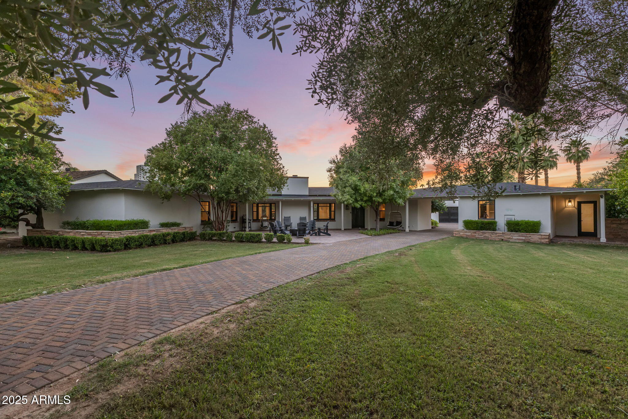 a front view of a house with a garden and trees