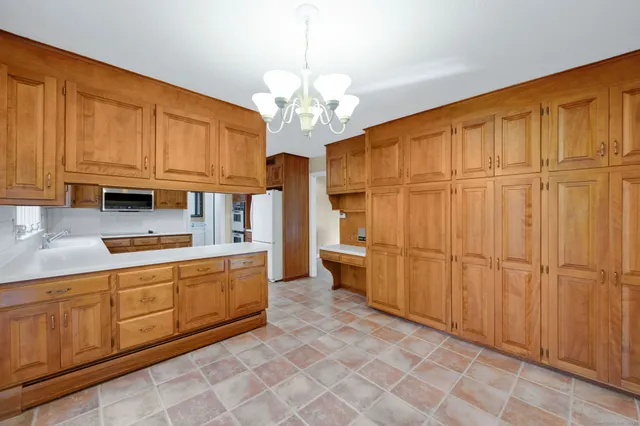 a kitchen with stainless steel appliances granite countertop a refrigerator a sink dishwasher and wooden cabinets