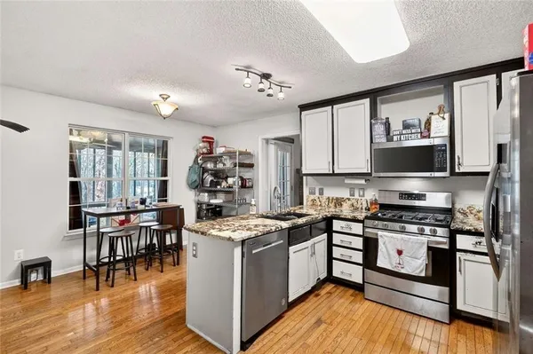 a kitchen with stainless steel appliances granite countertop a sink and stove