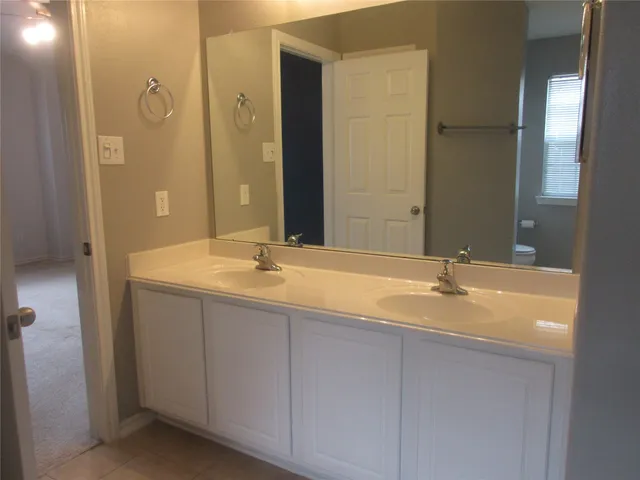 a bathroom with a granite countertop sink and a large mirror