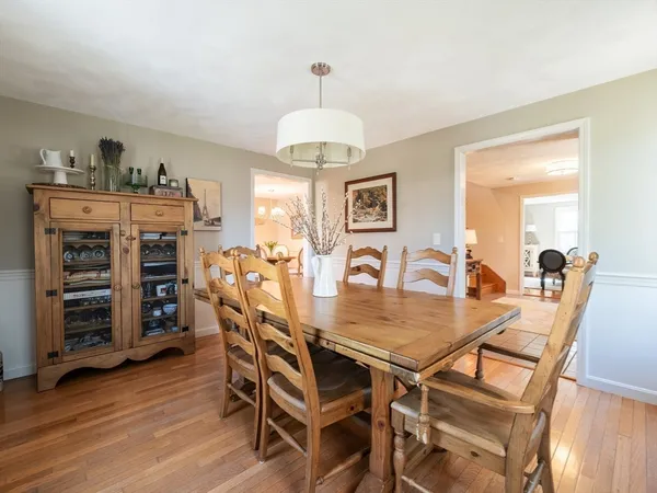 a kitchen with stainless steel appliances granite countertop a dining table chairs refrigerator and microwave