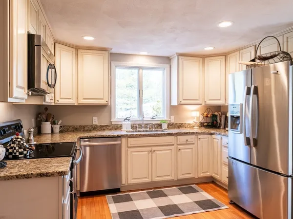 a kitchen with granite countertop appliances cabinets and a sink