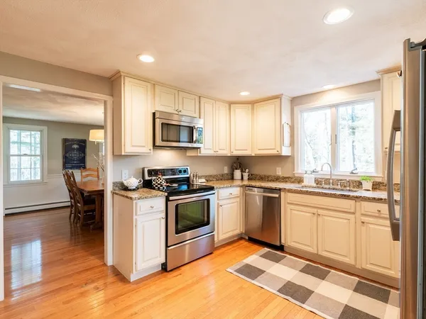a dining room with wooden floor a chandelier a wooden table and chairs