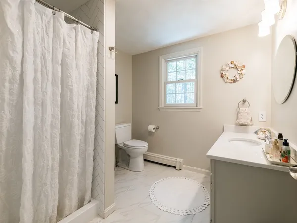 a bedroom with a bed and a dresser next to a window