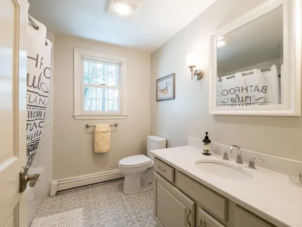 a bathroom with a sink a toilet and shower curtain