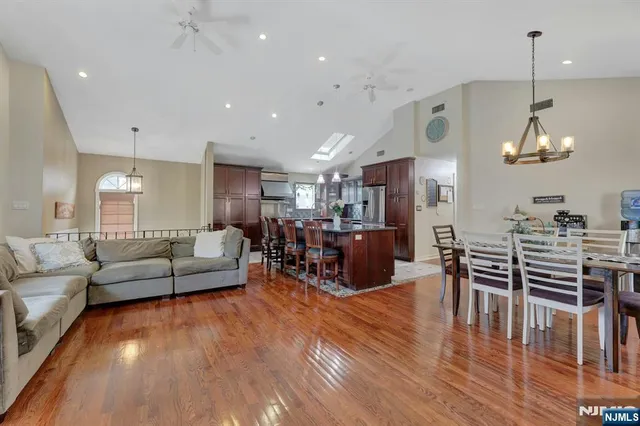 a living room with furniture kitchen view and a wooden floor