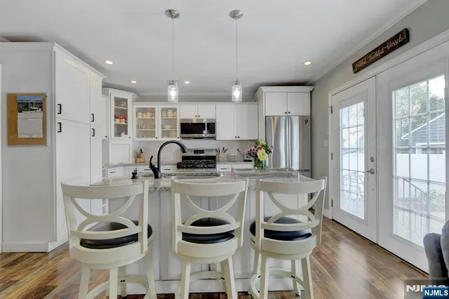 a kitchen with stainless steel appliances kitchen island granite countertop a refrigerator and a stove top oven