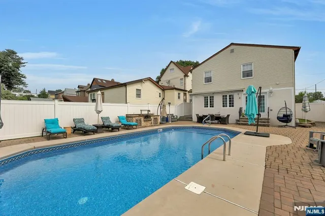a view of a house with swimming pool and sitting area