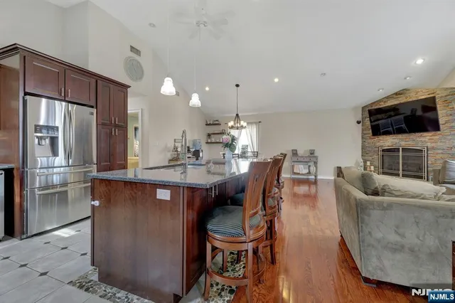 a living room with furniture a flat screen tv and kitchen view