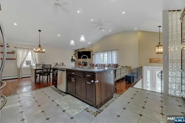 a kitchen with stainless steel appliances kitchen island granite countertop a table and chairs in it