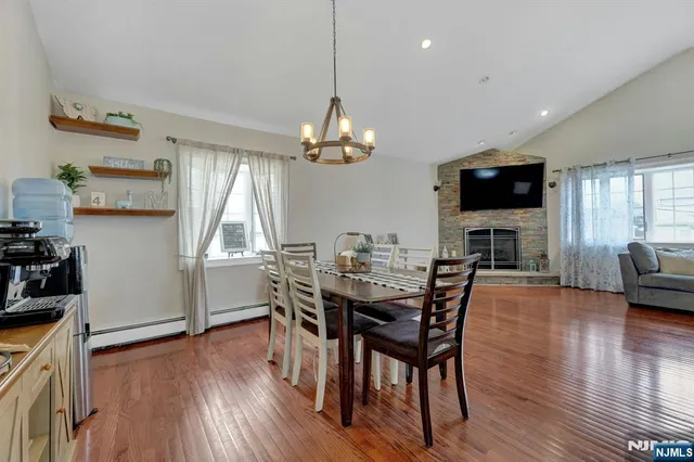 a view of a dining room with furniture a chandelier and wooden floor