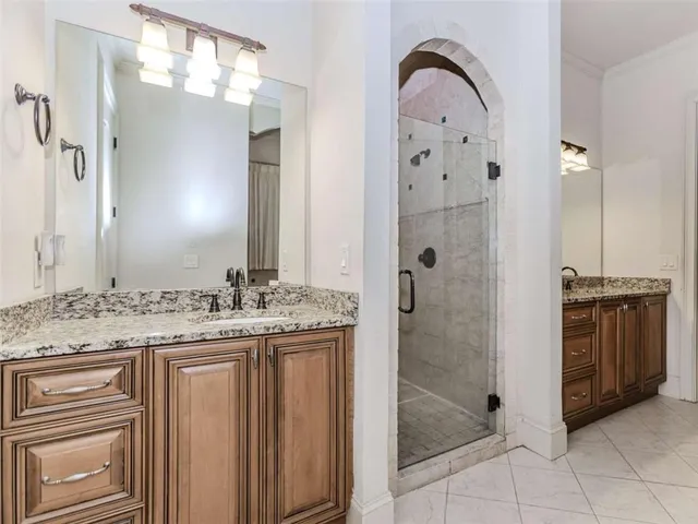 a bathroom with a granite countertop sink a shower and a mirror