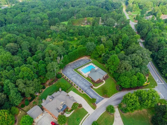 an aerial view of residential houses with outdoor space and trees