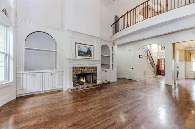 a view of empty room with wooden floor and fireplace