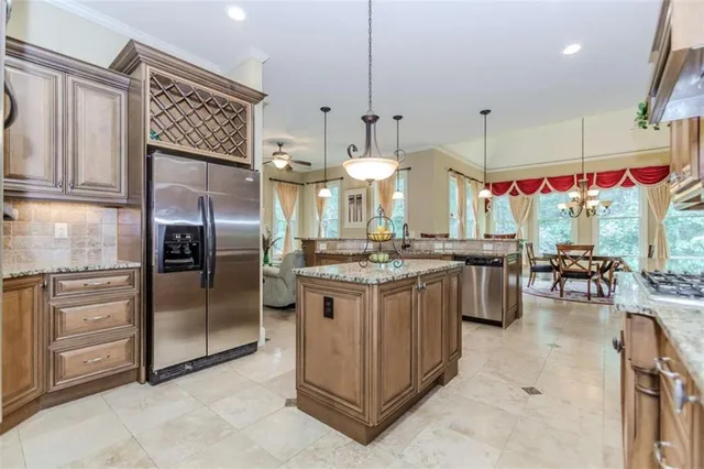a kitchen with stainless steel appliances granite countertop a stove a refrigerator and a view of living room
