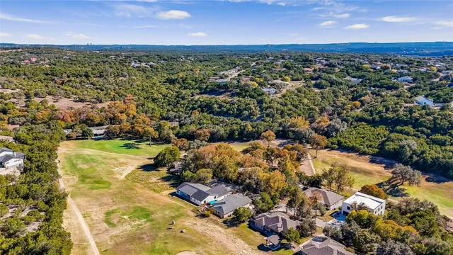 an aerial view of residential houses with outdoor space and trees