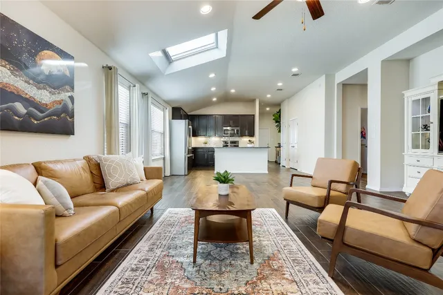 a living room with furniture and a view of kitchen