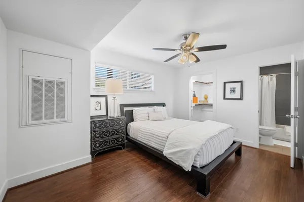 a bedroom with a bed chandelier and a window