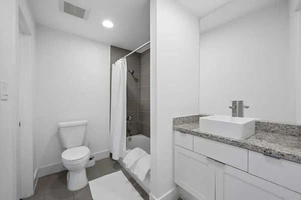 a bathroom with a granite countertop sink toilet and shower