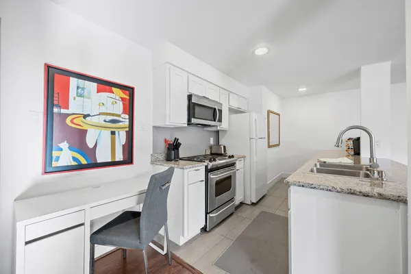 a kitchen with stainless steel appliances granite countertop a stove a sink and a microwave