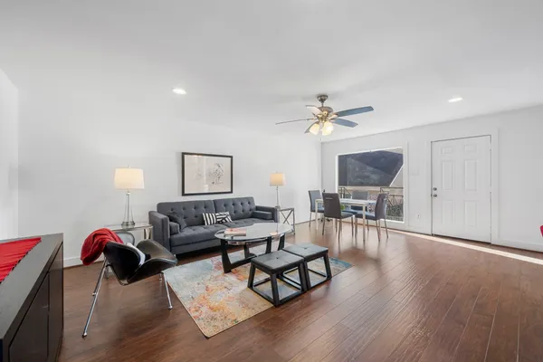 a living room with furniture and a wooden floor