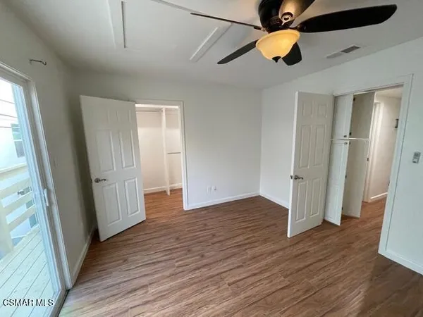 an empty room with wooden floor and door