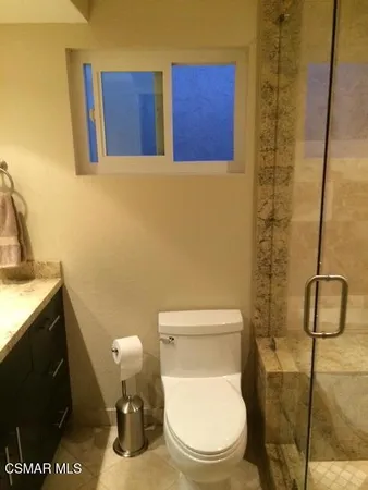 a white toilet sitting next to a bathroom sink