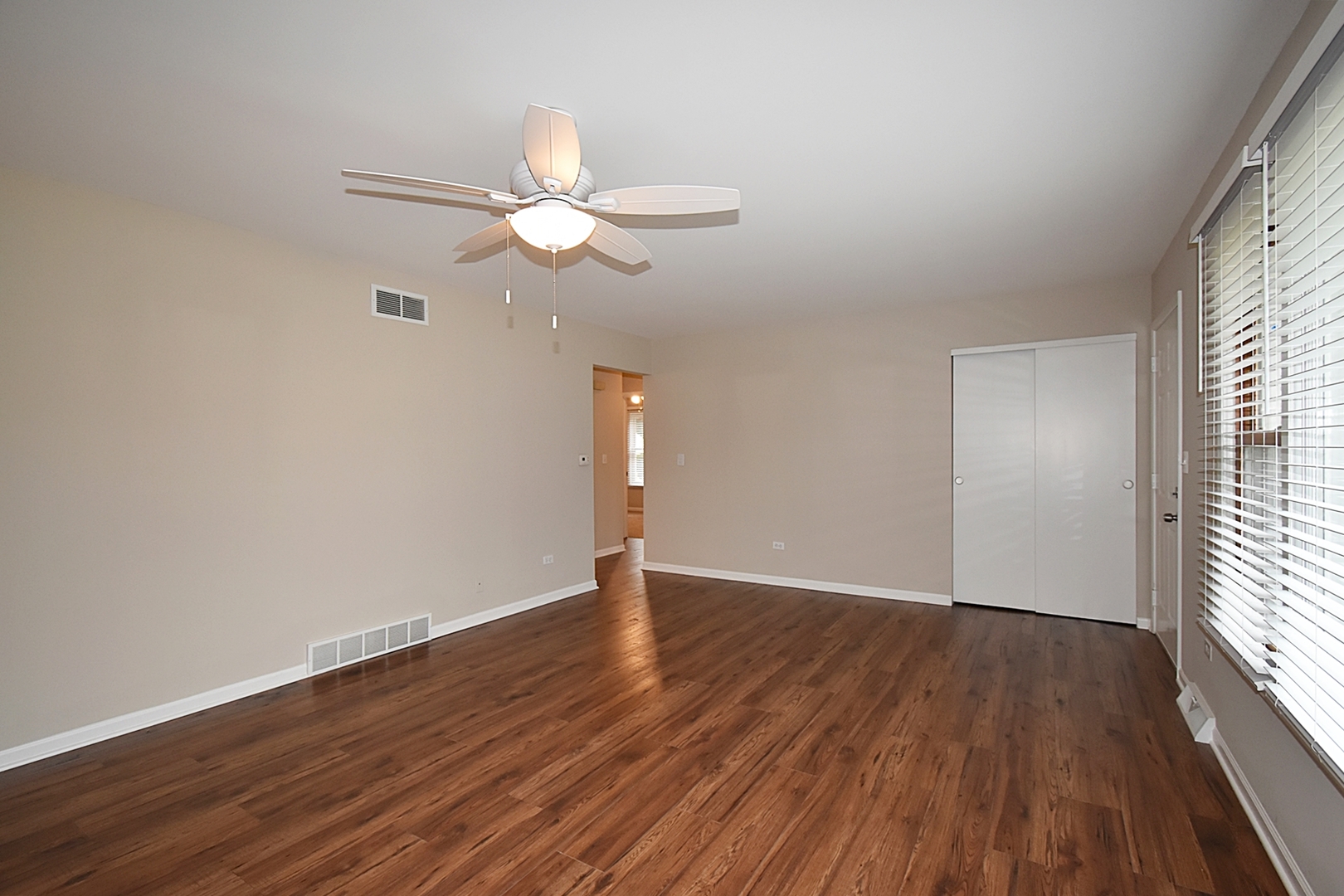 1191 Meadow Lane Elgin, IL 60123 - Photo 4 of 35 an empty room with wooden floor fan and windows