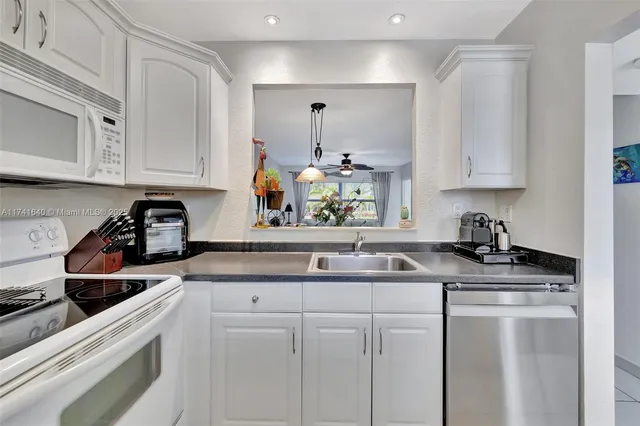 a kitchen with stainless steel appliances granite countertop a sink stove and cabinets