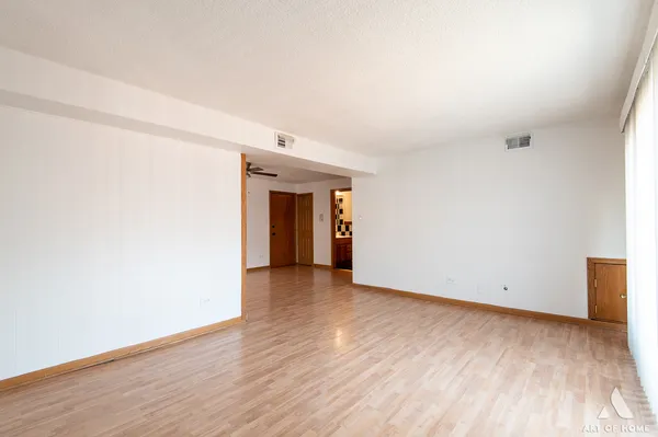 a view of an empty room with wooden floor