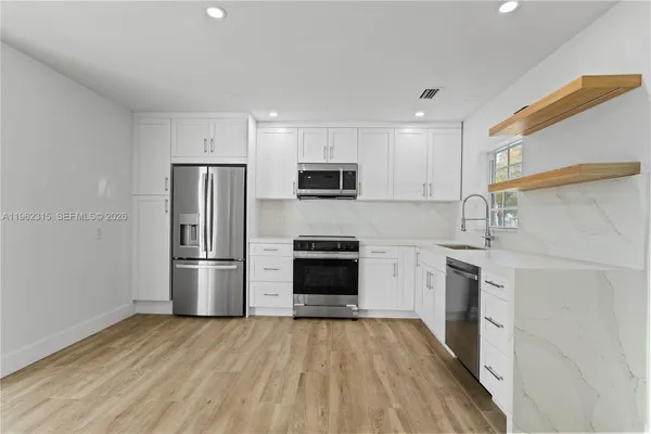 a kitchen with a stove a refrigerator and a microwave