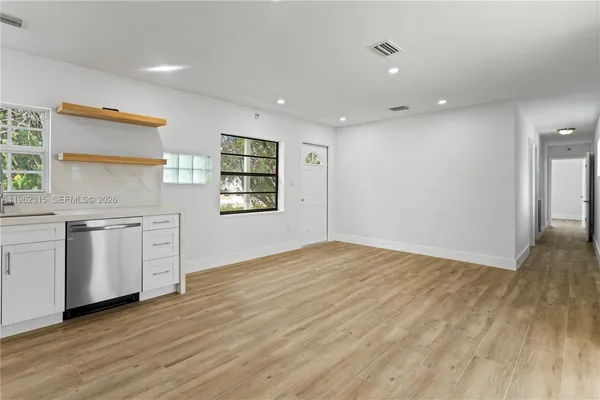 a view of a kitchen with wooden floor and electronic appliances