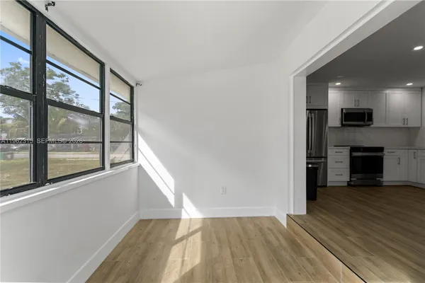a view of empty room with wooden floor and fireplace