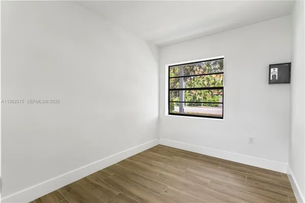 wooden floor in an empty room with a window