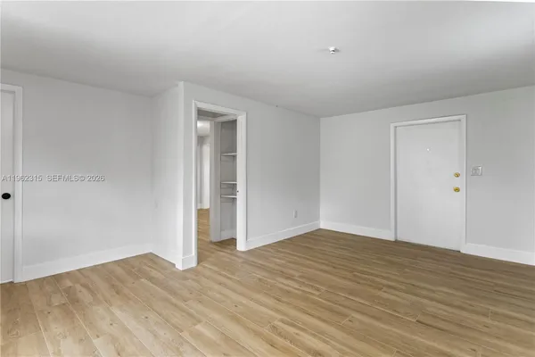 a view of an empty room with wooden floor