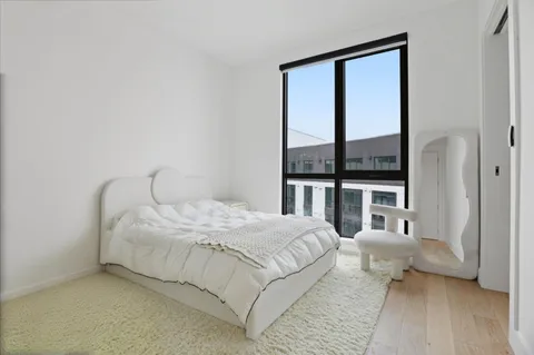a bedroom with a bed and a large window