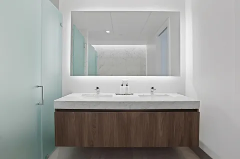 a bathroom with a granite countertop sink and a mirror