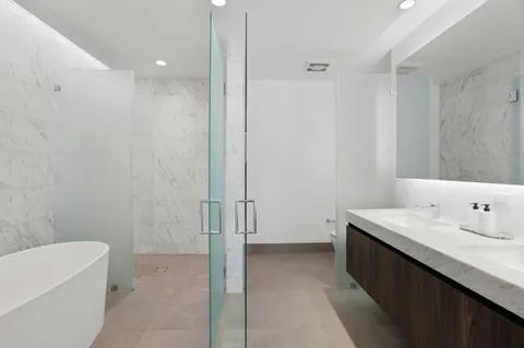 a bathroom with a sink a toilet and shower