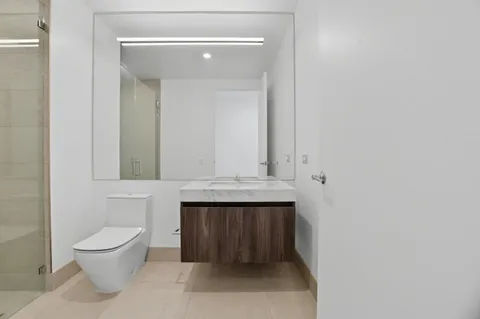 a bathroom with a toilet sink and mirror