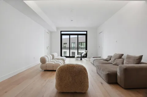 a spacious bedroom with a bed and glass window
