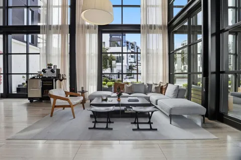 a living room with furniture and large windows