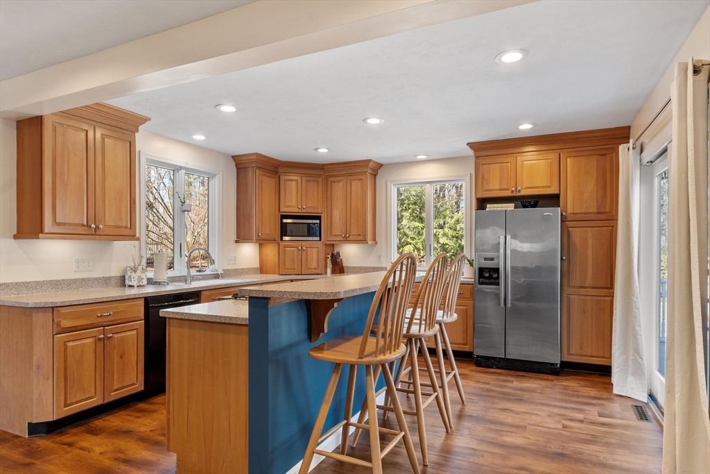 21 Potter Road Framingham, MA 01701 - Photo 9 of 42 a kitchen with stainless steel appliances granite countertop a table chairs refrigerator and sink
