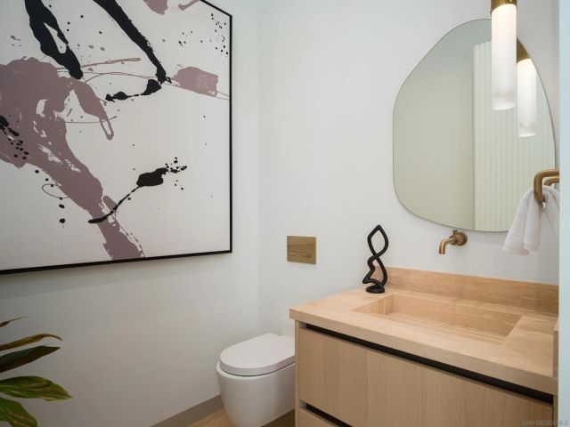 a bath room with a toilet a sink and a mirror