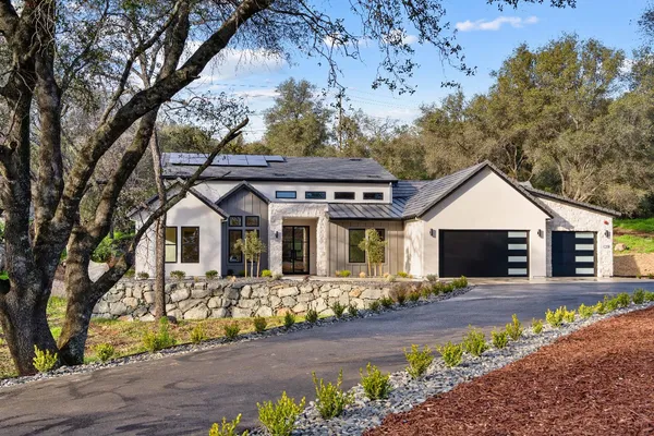 a front view of a house with a yard outdoor seating and mountain view