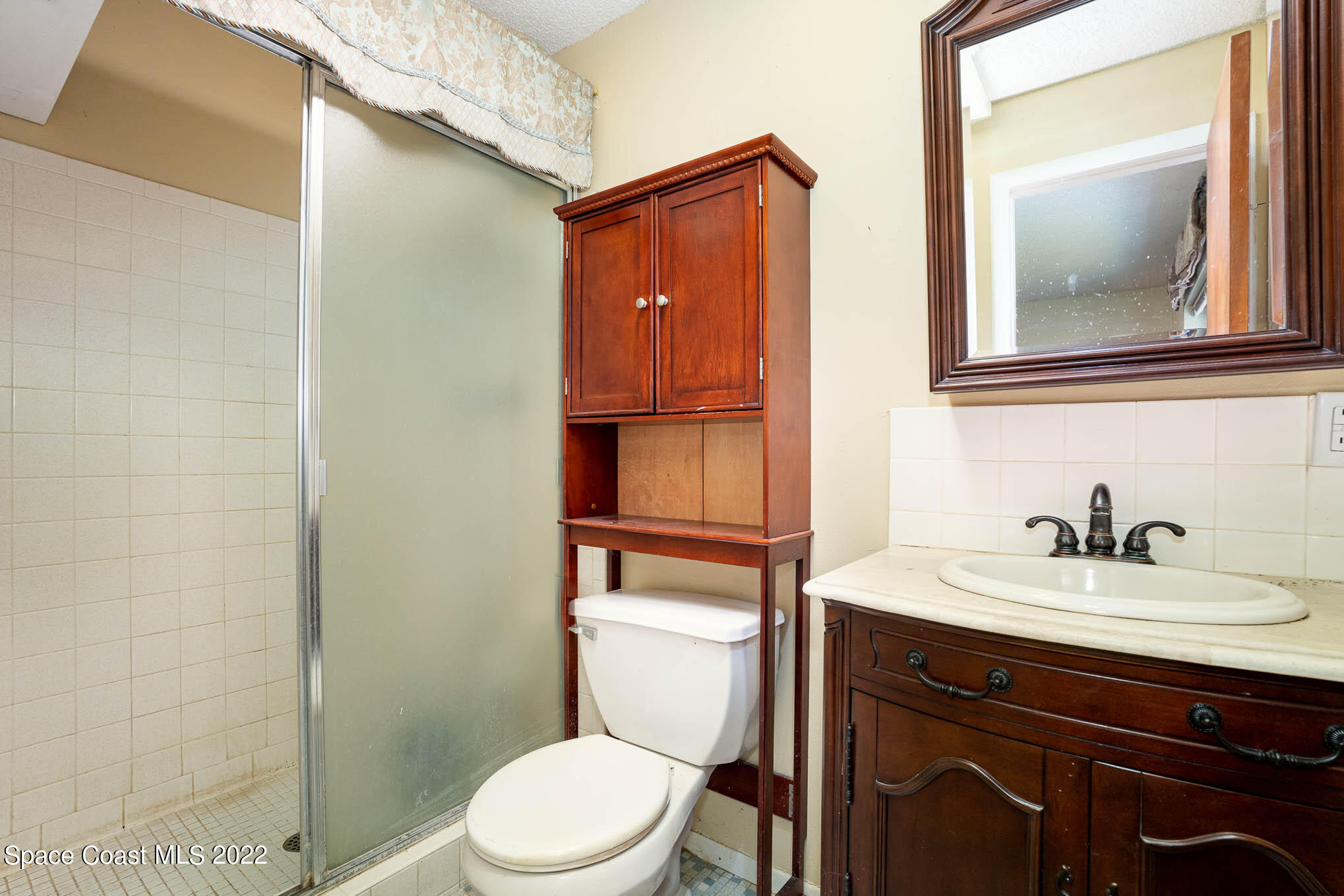 447 Count Street Melbourne, FL 32901 - Photo 12 of 24 a bathroom with a toilet a sink and mirror