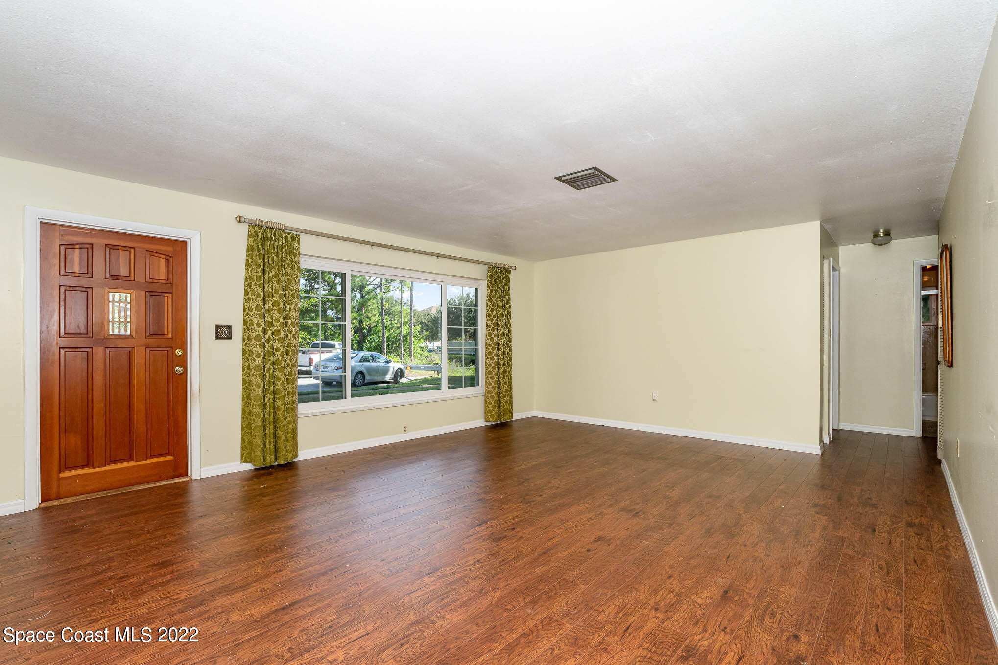 447 Count Street Melbourne, FL 32901 - Photo 4 of 24 a view of a big room with wooden floor and windows
